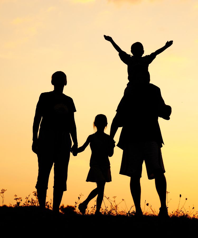 a silhouette of a family against a sunset